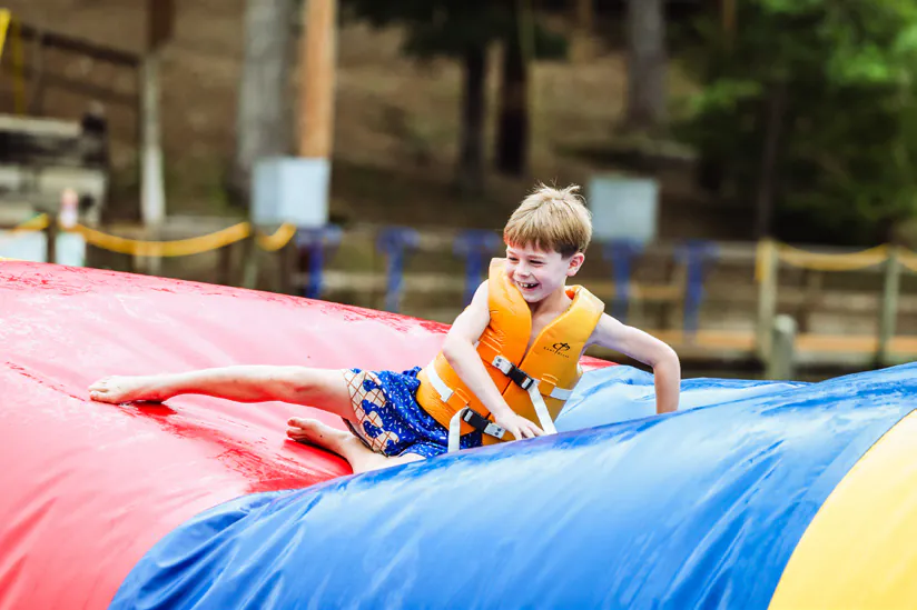 Camper in a life jacket on a water inflatable